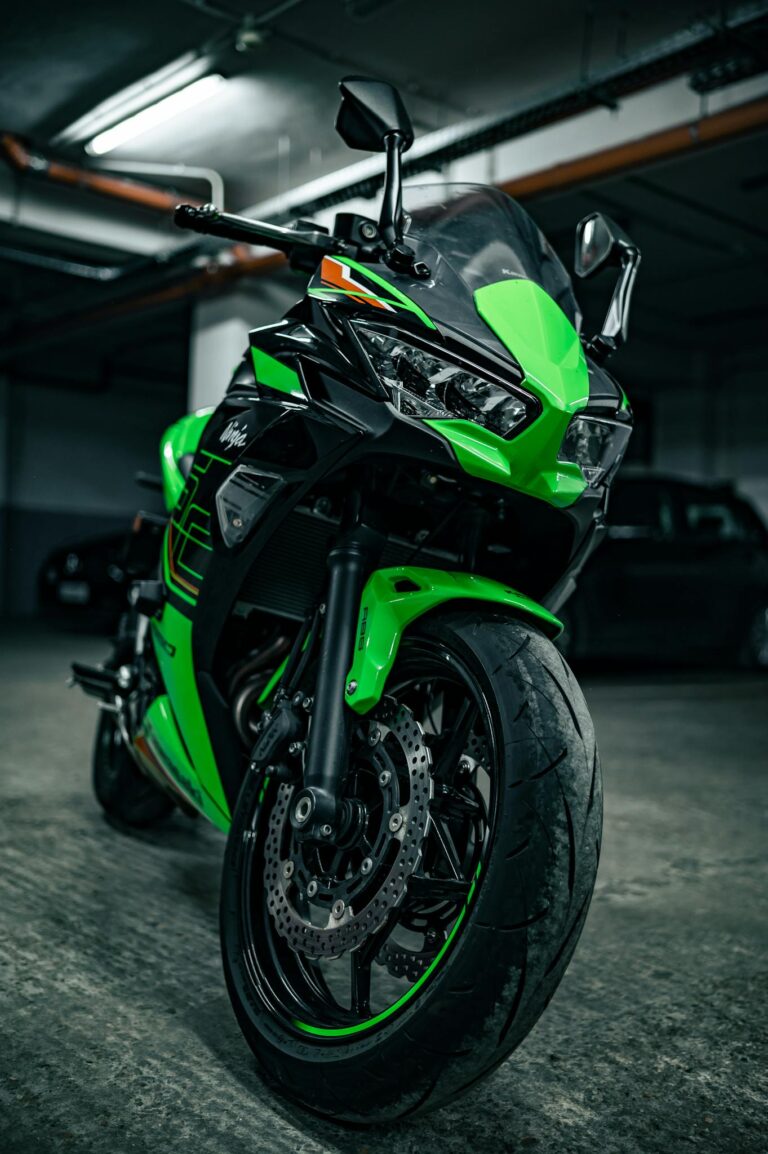 Vibrant green sport bike parked in an underground garage with dramatic lighting.